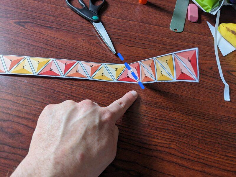 A creased strip with a blue dashed line down the border between two red triangles