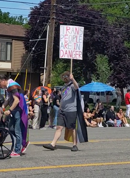 me holding a sign that reads "trans people are in danger"